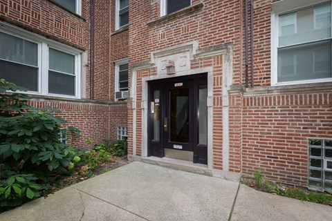 the front entrance of a brick building with a black door