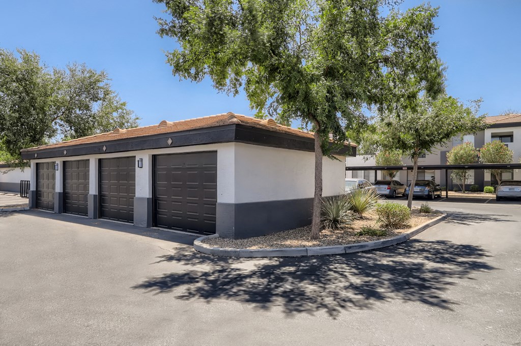 a building with a parking lot and a tree in front of it