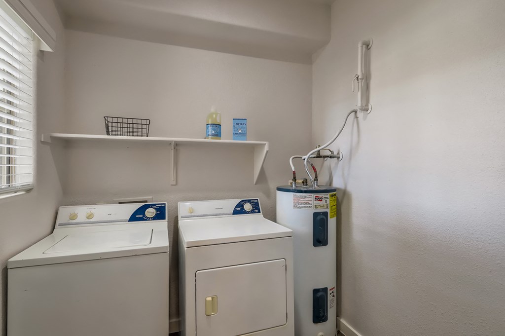 a laundry room with two washer and dryers and a window