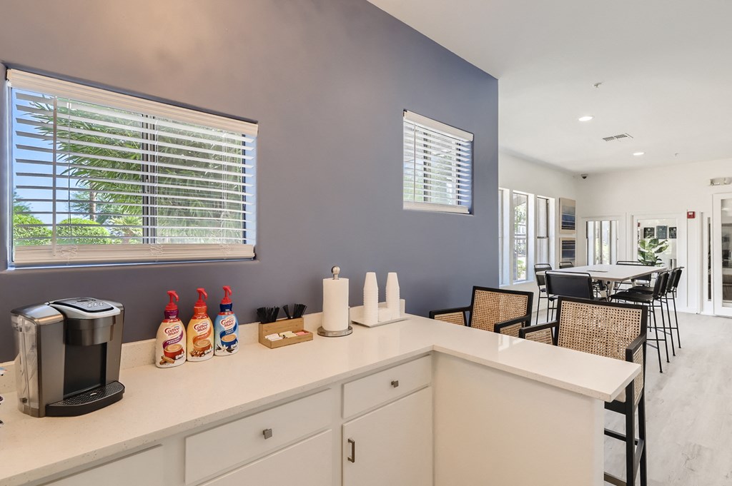 the kitchen and dining area of a house with a table and chairs