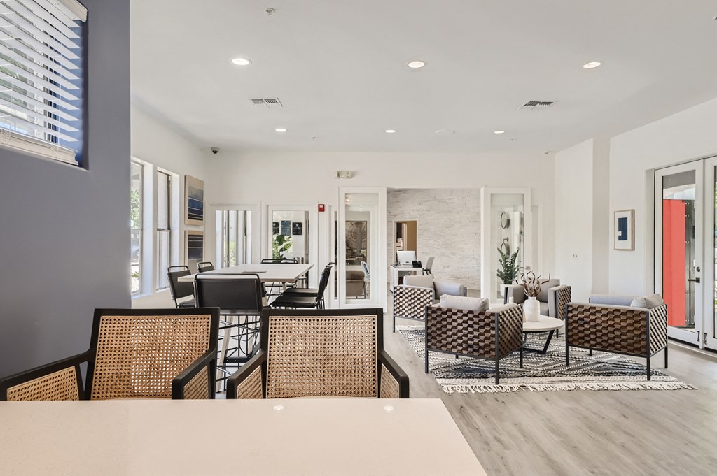 a large living room with chairs and tables and a large window