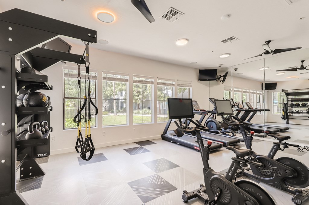 a home gym with exercise equipment and windows