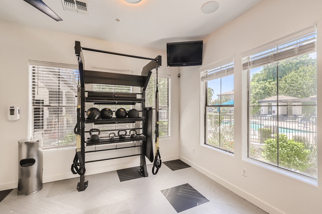 a workout room with a large window and a television
