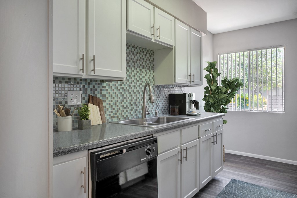a kitchen with white cabinets and a sink