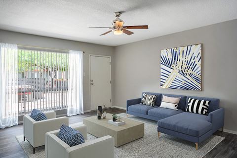 a living room with a blue couch and a ceiling fan