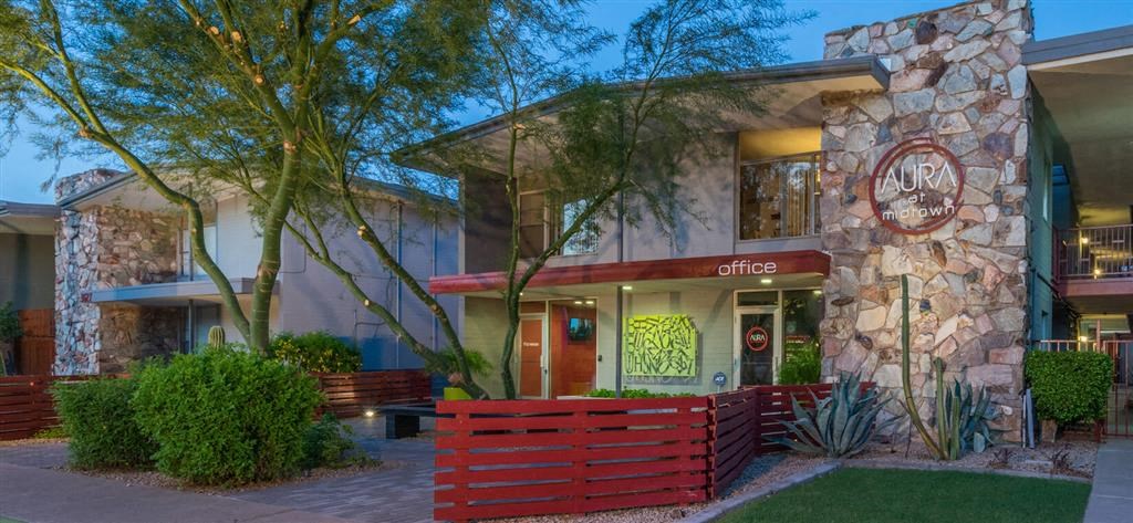 a restaurant with a stone facade and a red fence