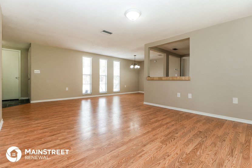 the living room and dining room with wood flooring