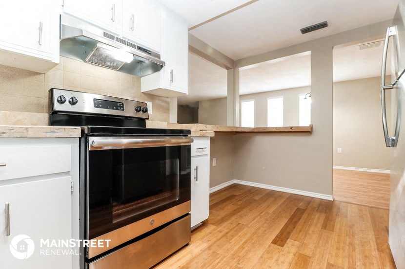 a kitchen with white cabinets and a stove and an oven