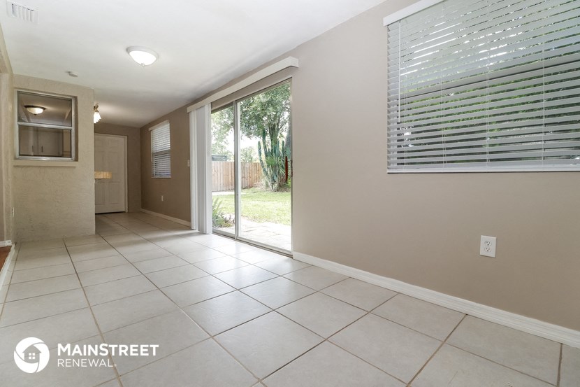 a spacious living room with a sliding glass door to the backyard