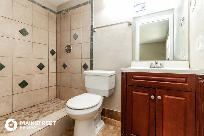 a bathroom with a toilet and a sink and a mirror