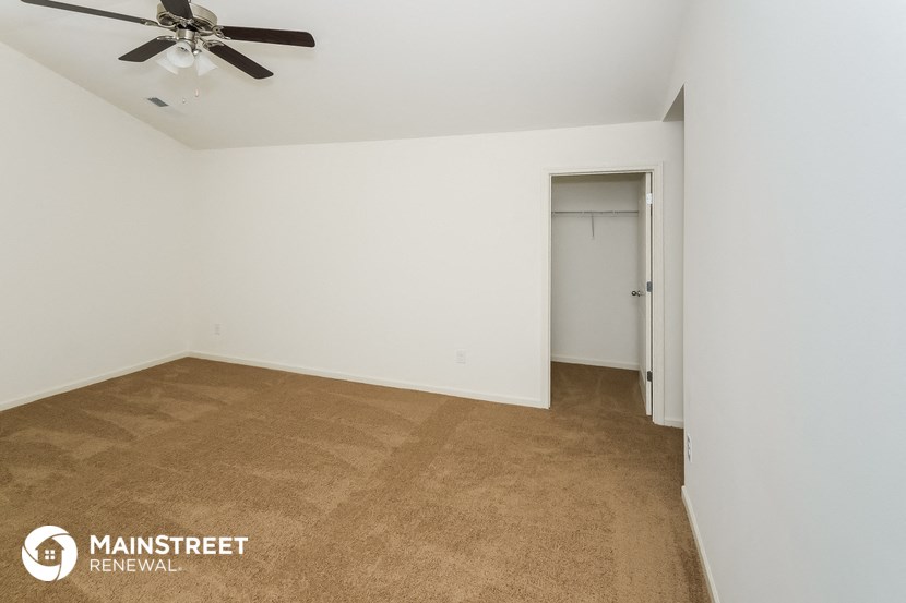 a room with a carpeted floor and a ceiling fan