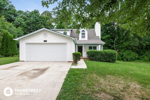 a white house with a white garage door and a driveway
