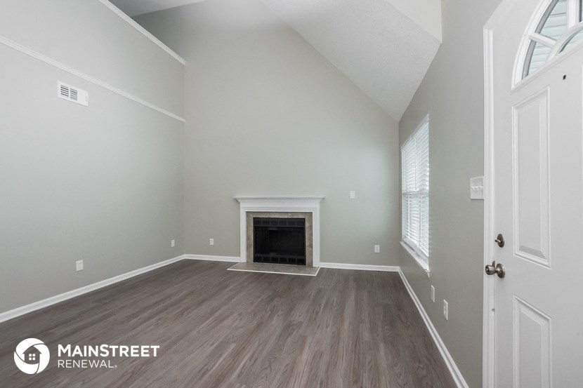 the living room with fireplace and wood flooring