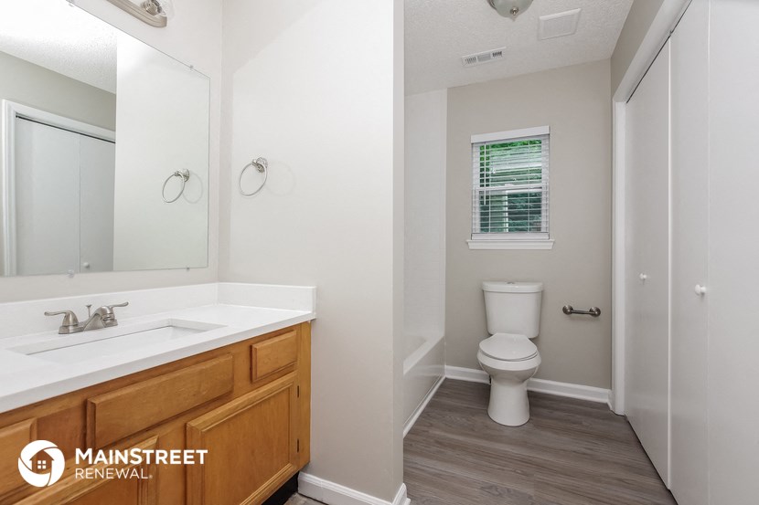 a bathroom with a toilet and a sink and a mirror