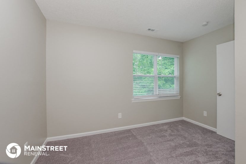 the upstairs bedroom with carpet and a window