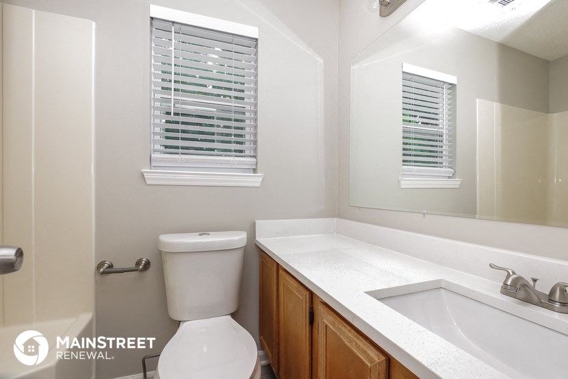 a bathroom with a toilet and a sink and a mirror