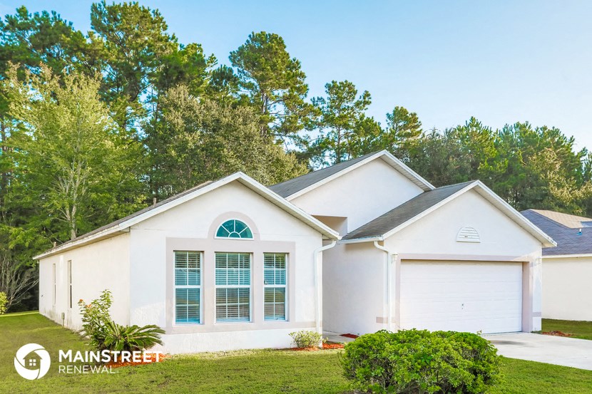 a white house with a lawn and trees