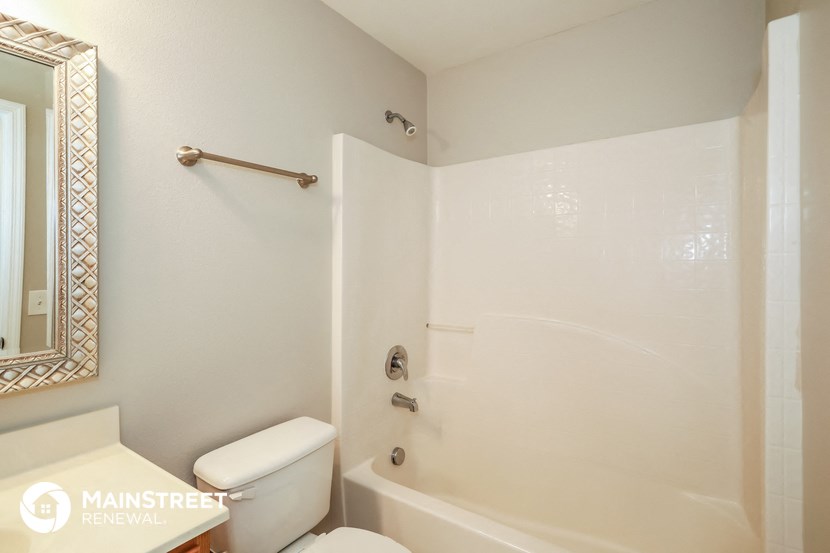 a bathroom with a shower and a toilet and a sink