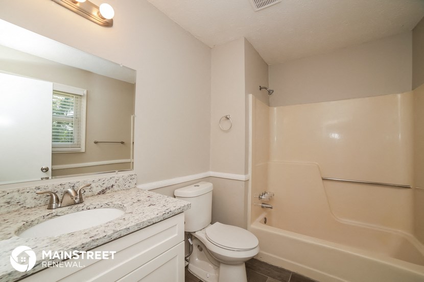 a bathroom with a tub and a sink and a toilet