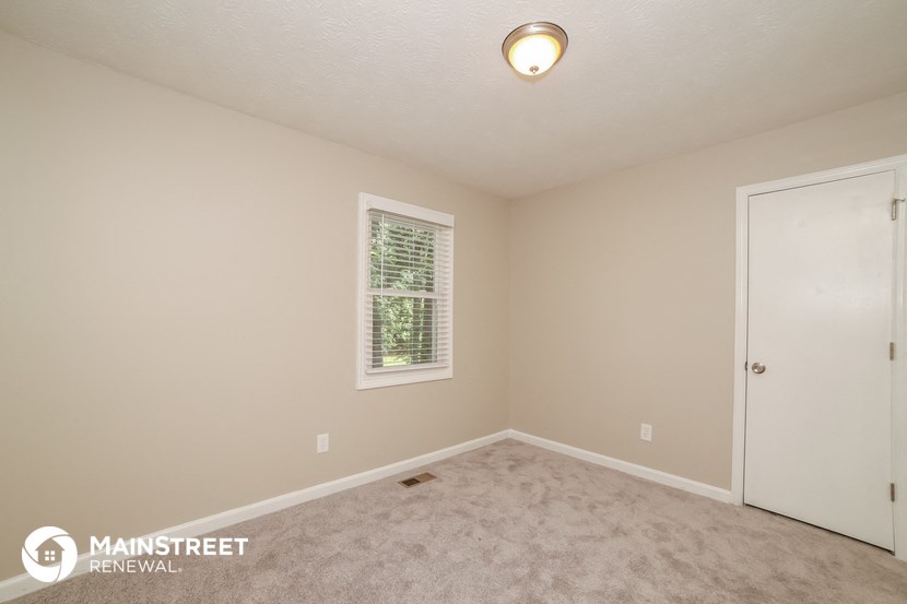 the upstairs bedroom with carpet and a door to the closet