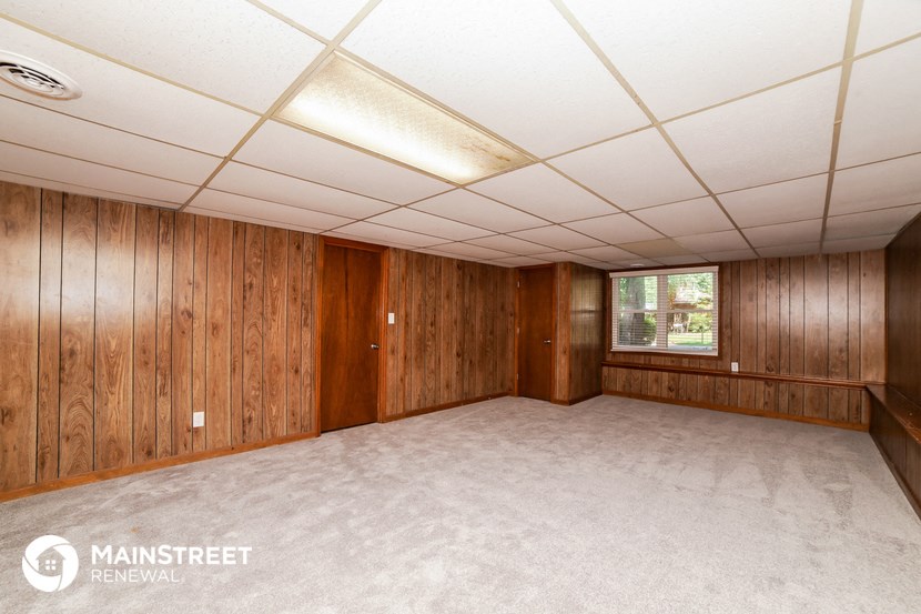 a room with a carpeted floor and wooden walls