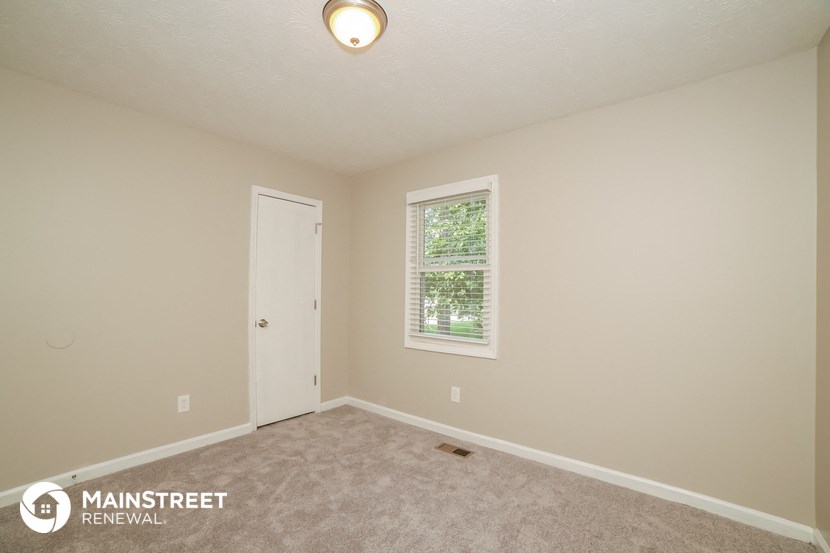 the upstairs bedroom with carpet and a door to the closet