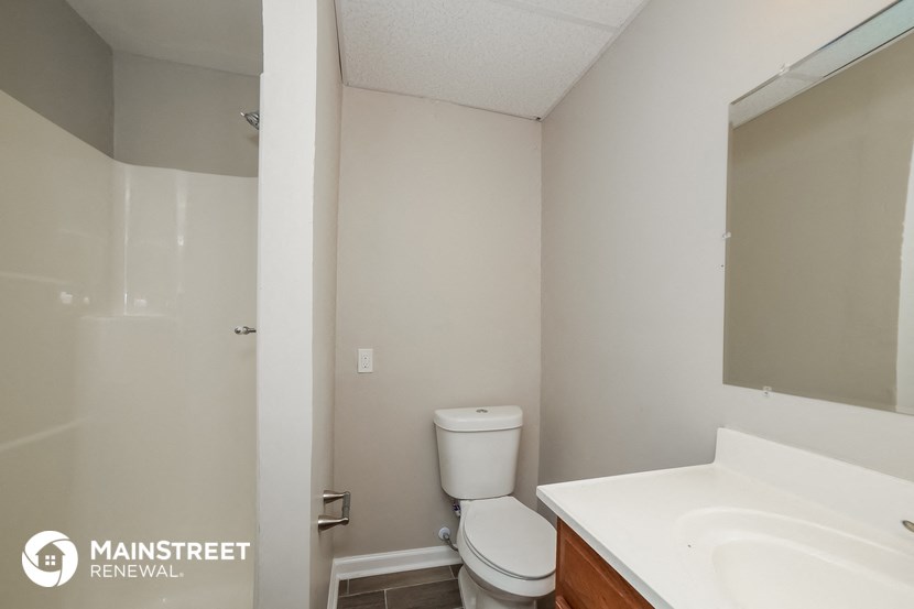 a bathroom with a toilet and a sink and a mirror