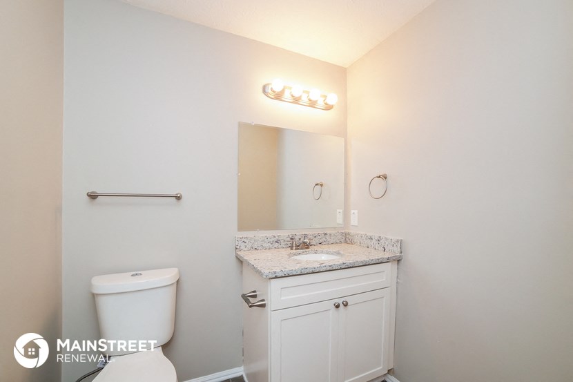 a bathroom with a toilet and a sink and a mirror