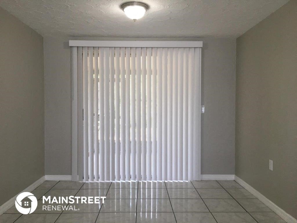 a large white vertical blinds in a room with a tile floor