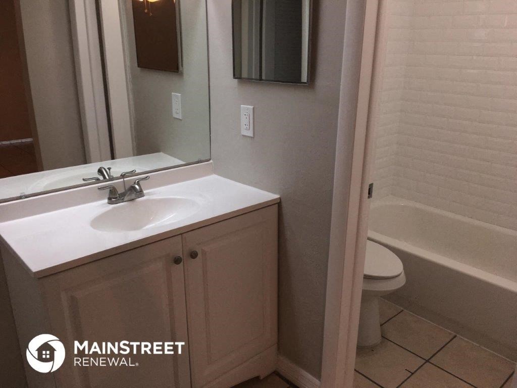 a bathroom with a sink and a toilet and a mirror