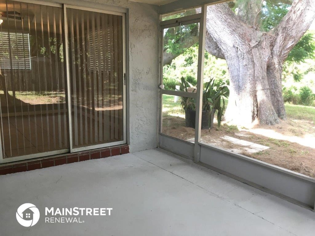an empty porch with a tree in the yard