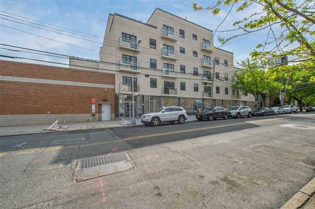 an apartment building on a city street with parked cars