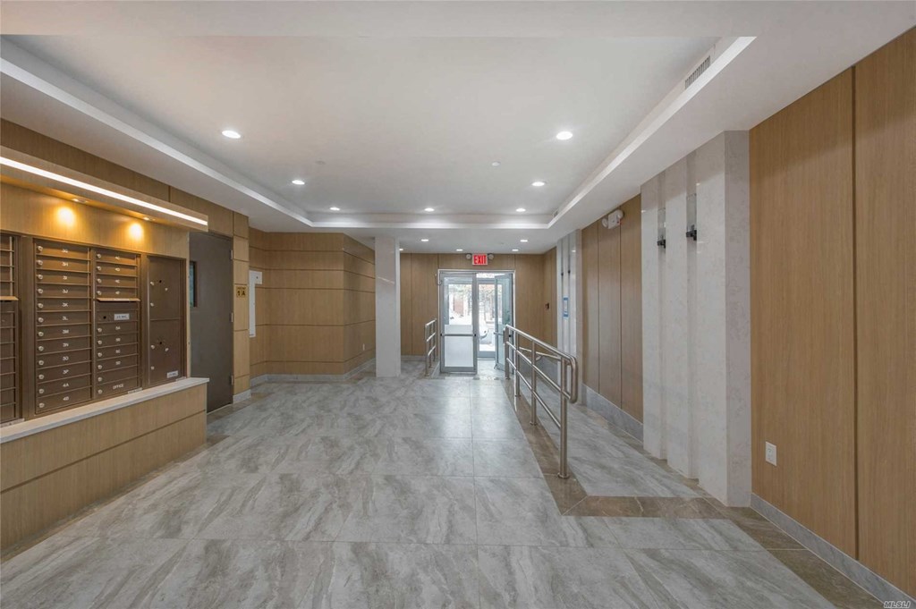 a large lobby with a staircase and a glass door