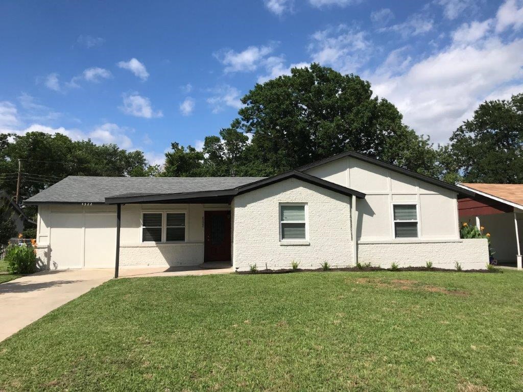 a white house with a green lawn and a blue sky