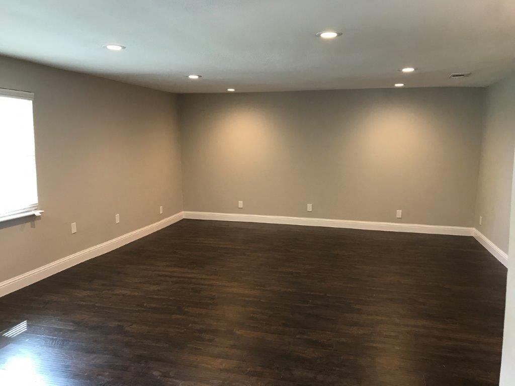 a empty living room with wood floors and a window