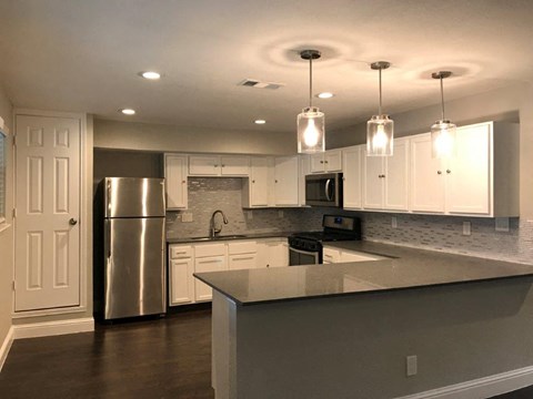 a kitchen with white cabinets and a stainless steel refrigerator