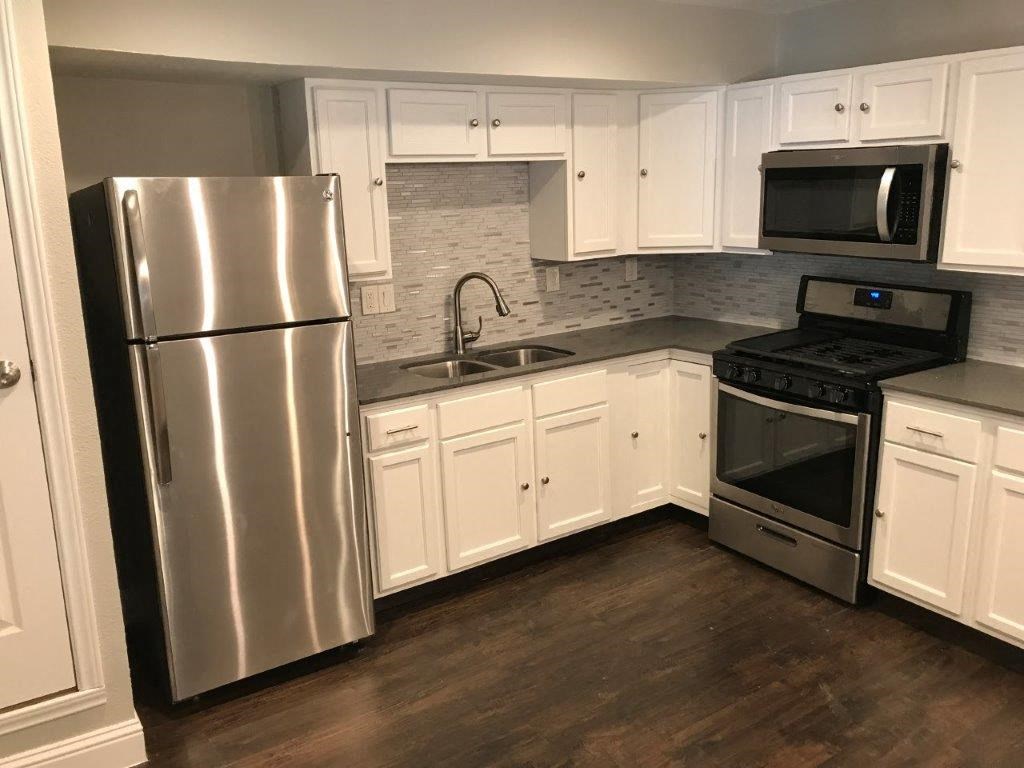a kitchen with stainless steel appliances and white cabinets