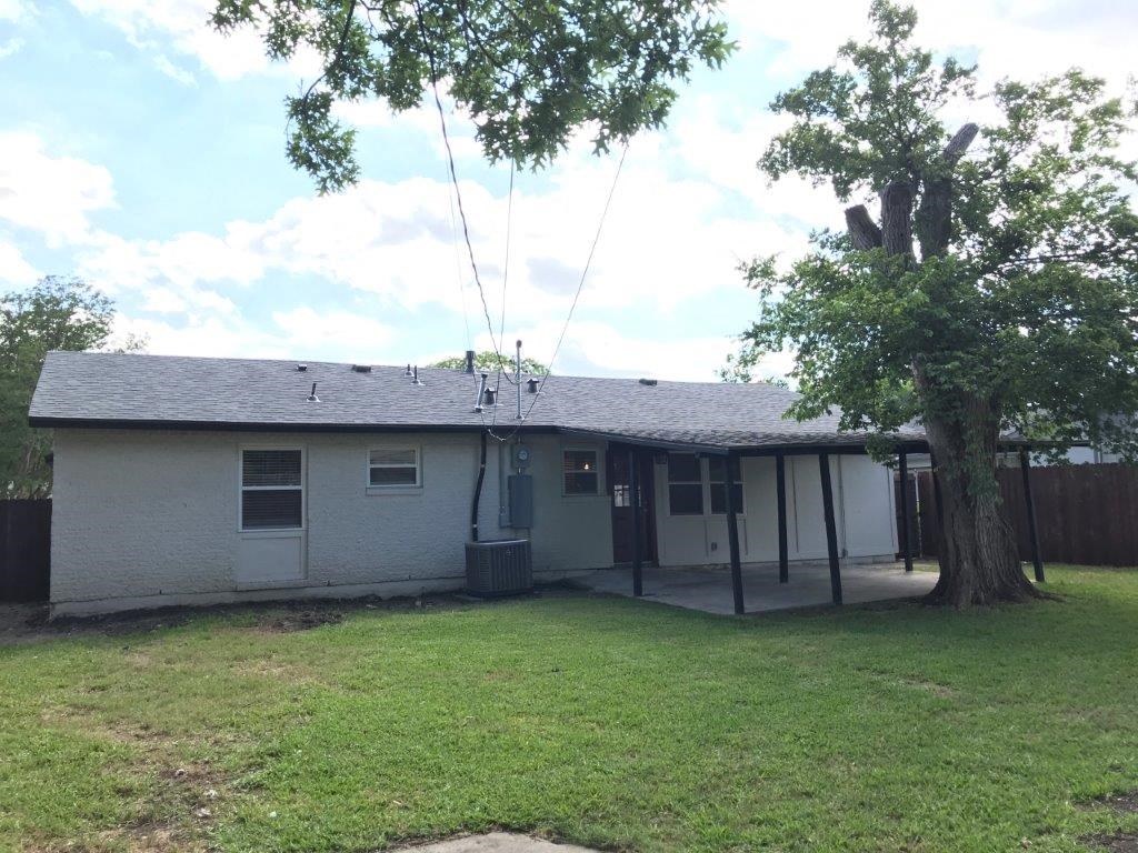 a white house with a yard and a tree