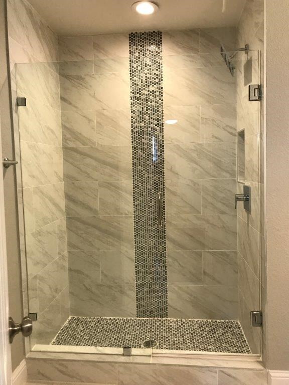 a bathroom with a shower with a glass door
