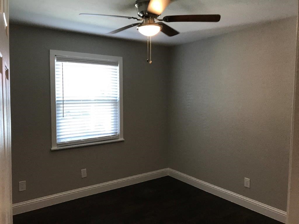 a living room with a ceiling fan and a window