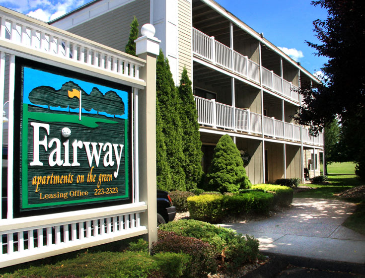a sign for fairway apartments on the run in front of a building