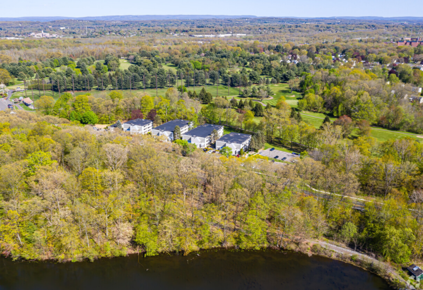 a aerial view of a neighborhood with trees and a body of water