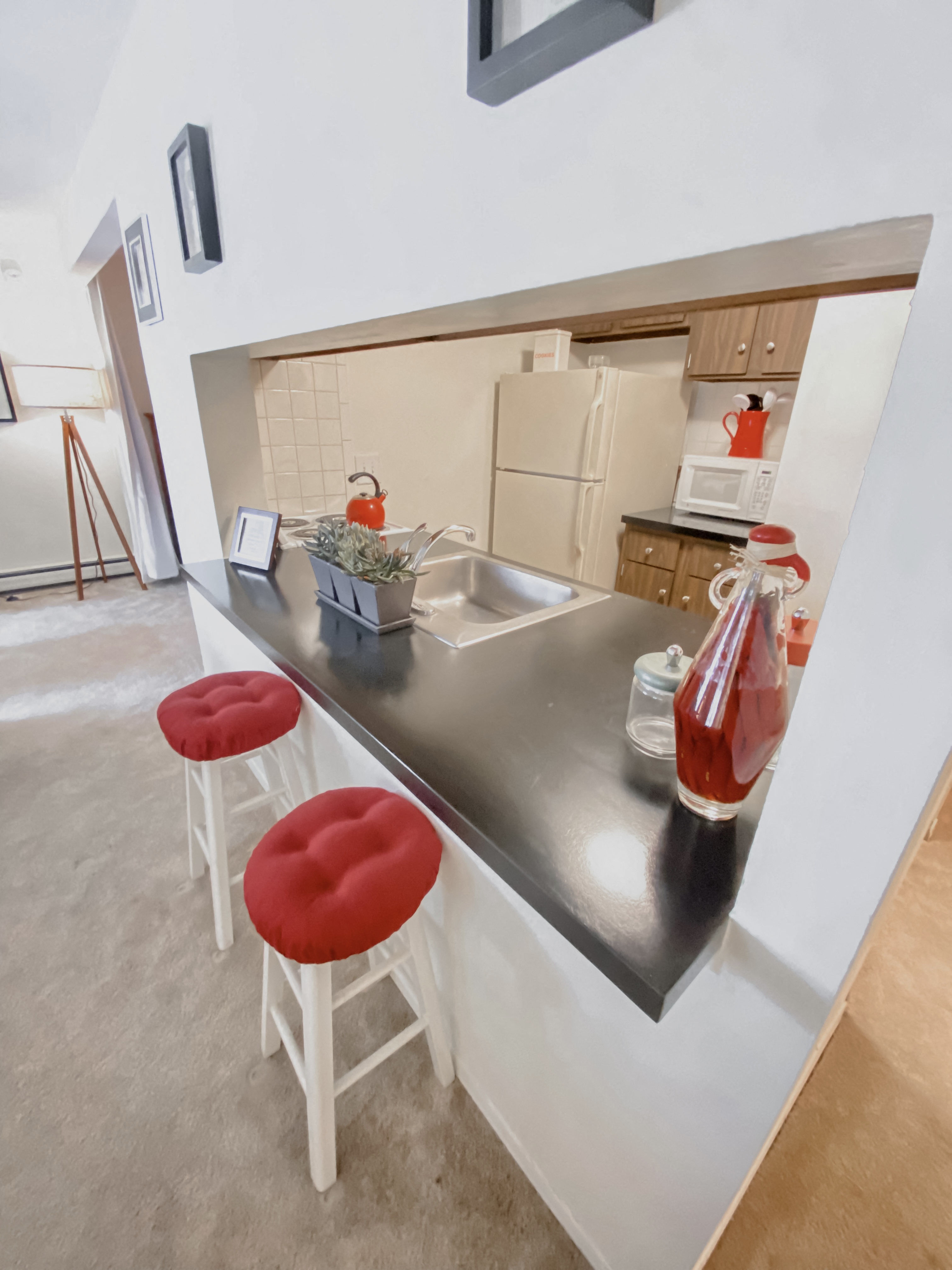 a kitchen with two stools and a counter with a sink