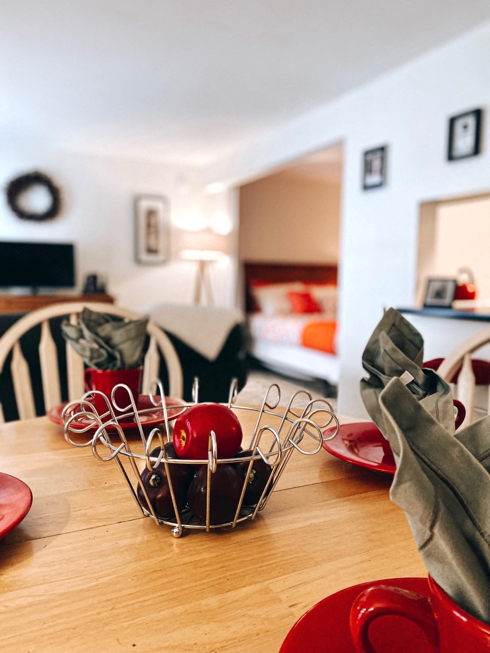 a dining room table with a basket with apples on it