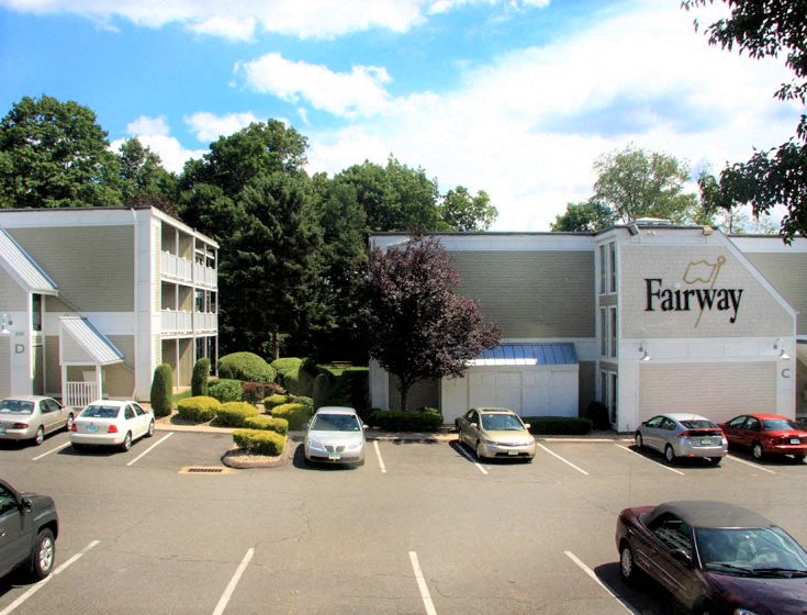 a parking lot with cars in front of a farmway building