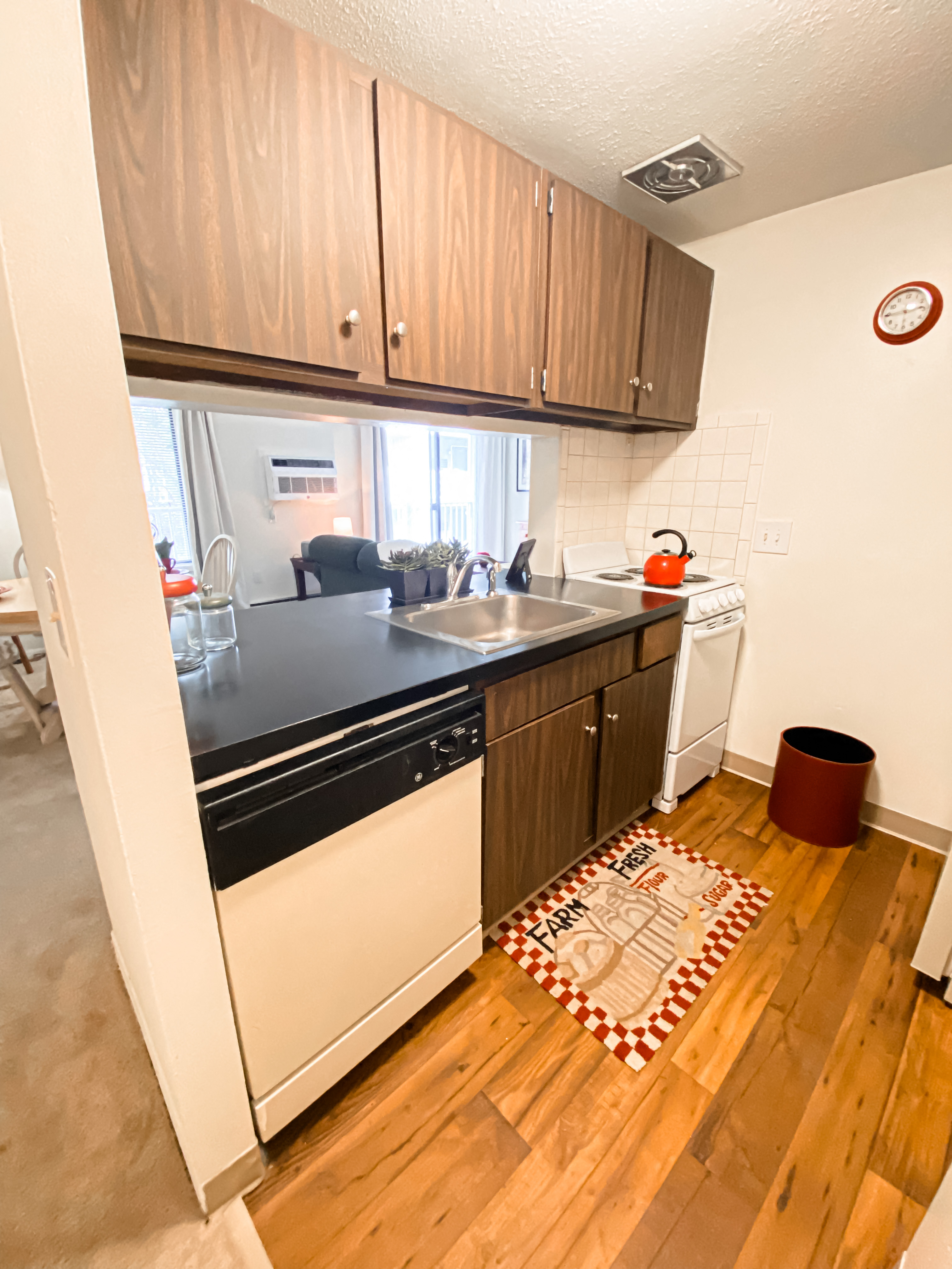 a small kitchen with wooden floors and white appliances