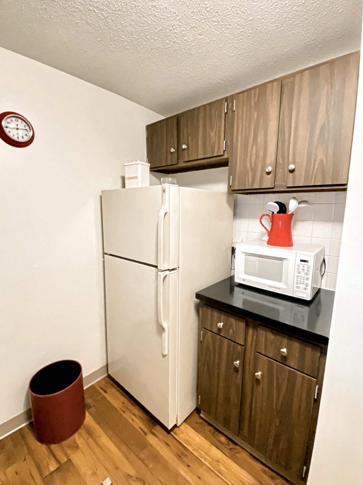 a kitchen with a refrigerator and a microwave and cabinets
