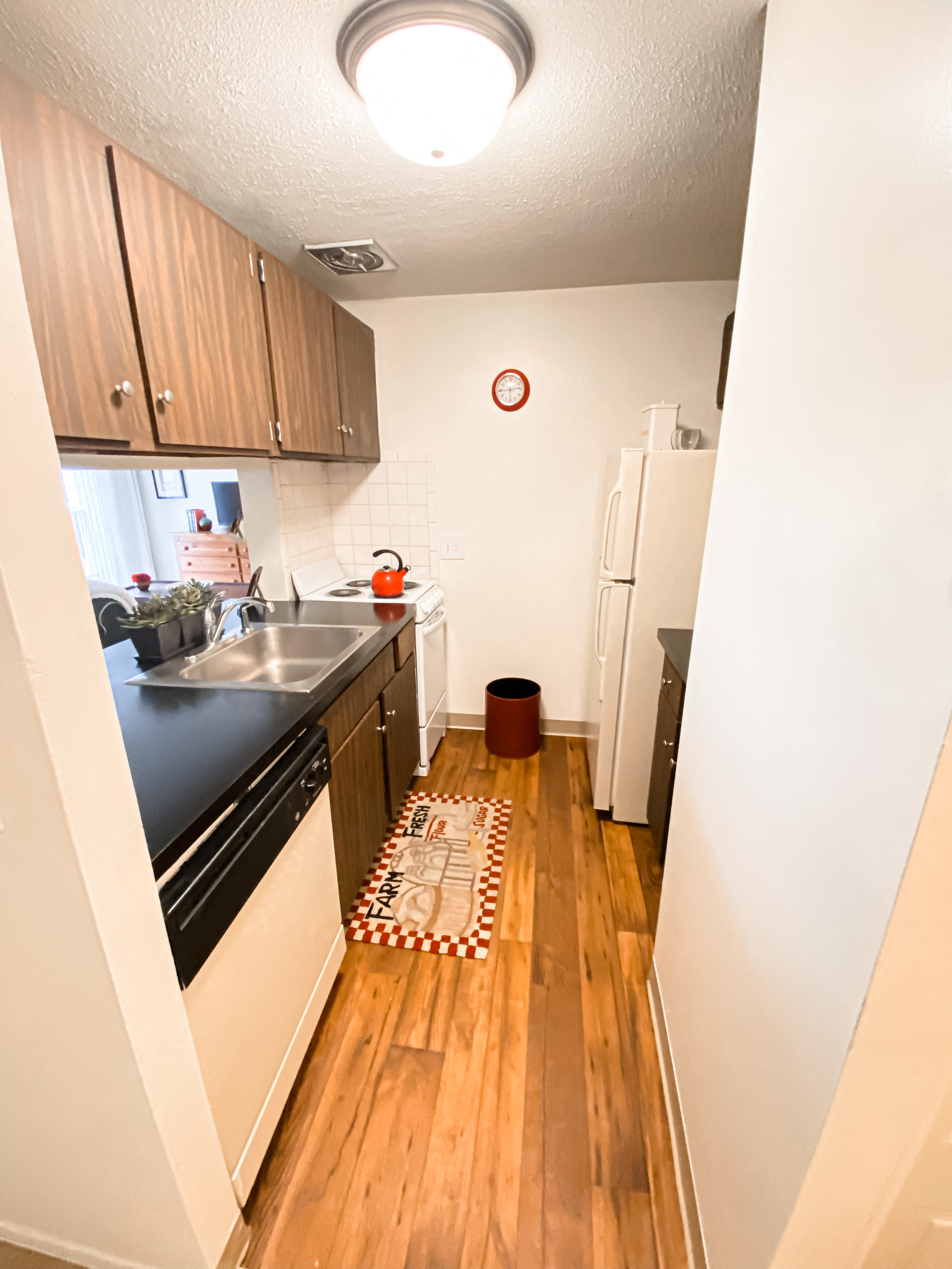 an empty kitchen with a refrigerator and a sink