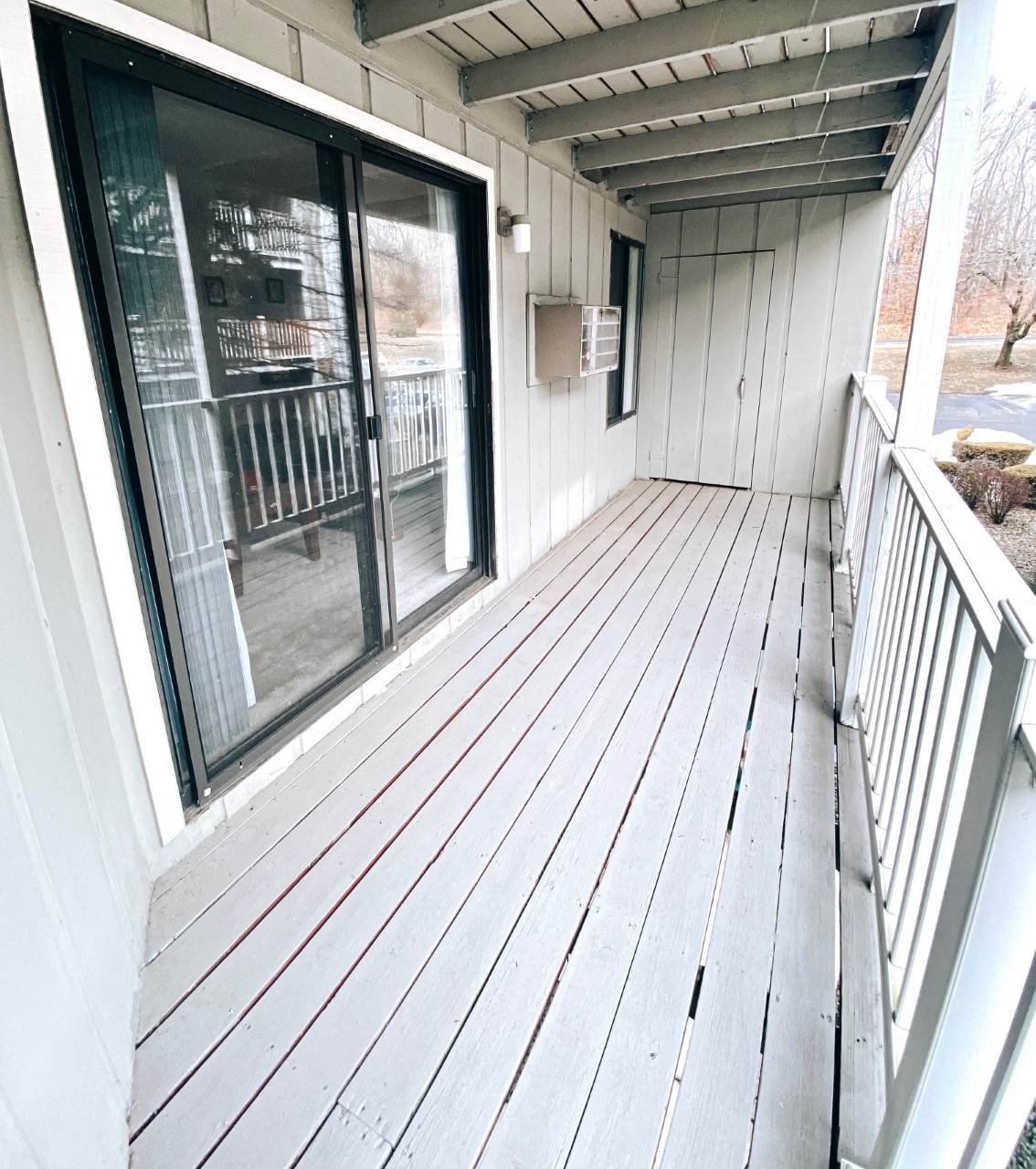the front porch has a wood deck and a large window