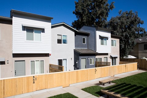 a row of multifamily homes with a wooden fence